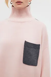 Women's pink turtleneck sweater with contrast grey chest pocket, loose knit winter top.
