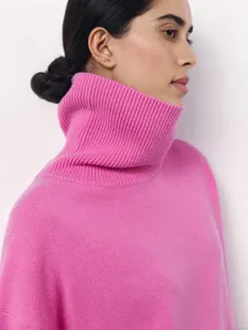 Pink turtleneck sweater detail, soft knit fabric, cozy winter long sleeve topwear.