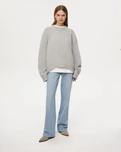 Oversized grey crewneck knit sweater worn by model, relaxed drop-shoulder fit style.