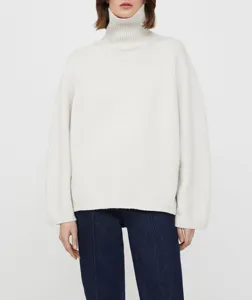 Close-up detail of a soft ribbed turtleneck knit sweater in off-white, featuring high collar.