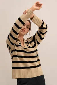 Detailed shot of striped knit polo sweater with contrast sleeves and comfortable loose fit style.