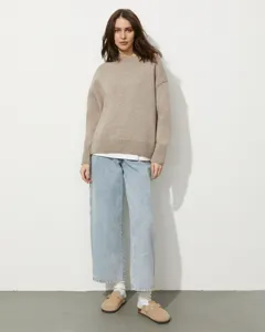 Detailed scene presentation showing the cozy beige knit sweater in a professional studio setting.
