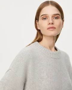 Close-up detail of women's casual grey crewneck knit sweater texture and comfortable collar fit.