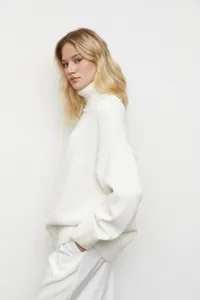 Vue détaillée d'un pull col roulé blanc douillet à coupe décontractée pour l'hiver.