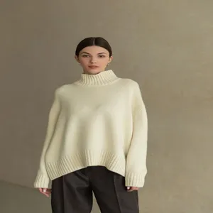 Detailed view of women's cozy mock neck knit sweater in cream color, loose fit autumn style.