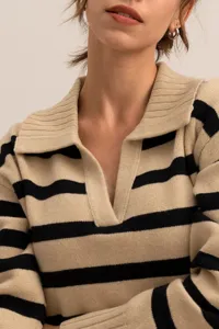 Detail view of a stylish knitted polo collar sweater featuring chic black and beige stripes.