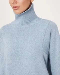 Close-up view of a women's light blue turtleneck knit sweater featuring classic ribbed collar.