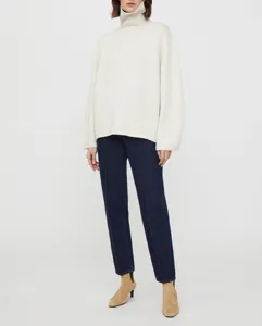 Detailed view of women's cozy knit turtleneck sweater featuring long sleeves and loose fit style.