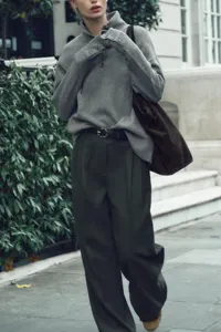 Elegant grey mock neck sweater styled with dark trousers for a chic autumn look.