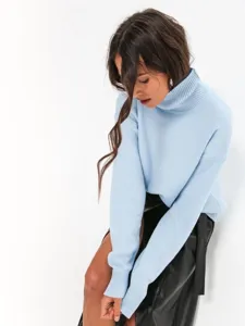 Close-up view of a cozy light blue turtleneck sweater featuring soft knit fabric and ribbed collar.