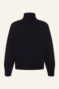 Detailed view of a classic black turtleneck sweater, featuring ribbed collar and cuffs.