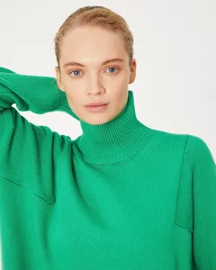 Cozy green turtleneck sweater detail showcasing soft knit texture and comfortable loose fit style.