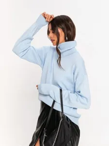 Detailed view of women's light blue turtleneck knitted sweater, soft fabric and loose fit style.