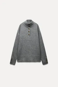 Grey mock neck knit sweater featuring front button placket and decorative cuff buttons.