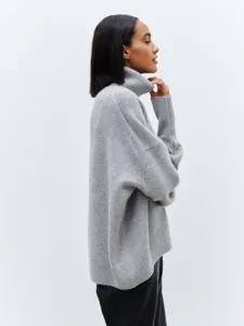 Grey oversized turtleneck knit sweater detail, soft wool blend fabric, cozy winter apparel.