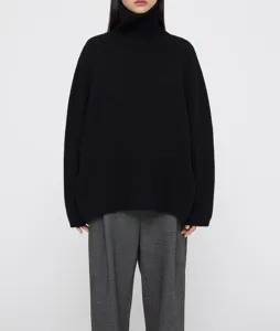 Close-up detail of the black wool turtleneck sweater, showing soft knit texture and collar.