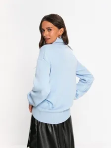 Detail view of a casual loose turtleneck sweater for women, comfortable long sleeve knitwear.