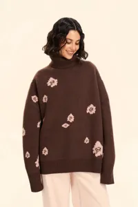 Close-up view of the brown knit turtleneck sweater showcasing pink floral jacquard patterns.