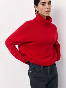 Close-up detail of a bright red turtleneck sweater worn by a model, soft knit texture.