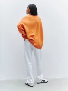 Detailed view of women's cozy orange loose-fit long sleeve V-neck knitwear sweater, elegant.