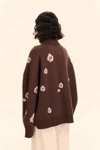 Back view detail of brown turtleneck knit sweater with pink floral jacquard pattern.