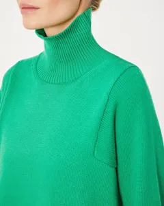 Green turtleneck knit sweater detail, cozy winter women pullover with ribbed high collar.