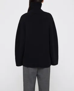 Back detail shot of black wool blend turtleneck sweater showing fine knit texture.
