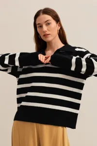 Close-up detail of the black and white striped knit polo sweater showcasing collar and texture.