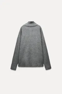 Detailed shot of grey mock neck knit sweater, soft texture, cozy autumn winter apparel.