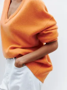 Cozy casual orange V-neck knitted sweater for women, loose long sleeve pullover top.
