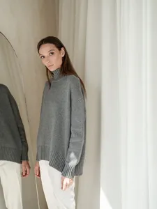 Grey turtleneck sweater detail view, soft knit fabric texture, comfortable loose fit style for women.