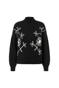 Black mock neck knit sweater featuring elegant white floral embroidery for autumn and winter.