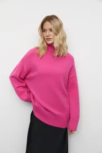 Gros plan montrant la texture de tissu confortable et le col roulé du pull rose.