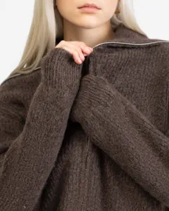 Brown knit cardigan detail showing cozy texture, zipper collar, and stylish chunky design.