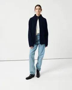 Close-up view of a cozy navy blue ribbed knit zip cardigan, showcasing high collar and cuffs.