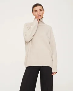 Detailed view of women's cozy high-neck knitted sweater featuring a relaxed fit.