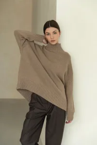 Close-up detail of a cozy taupe turtleneck knitted sweater, soft wool texture, elegant fashion style.