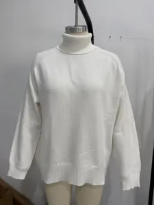 Detail view of a cozy white turtleneck sweater, featuring loose fit and ribbed knit cuffs.