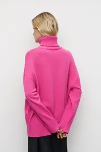 Vue détaillée au dos d'un pull oversize rose vif à col roulé élégant pour femmes.