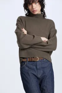 Detail view of a cozy ribbed turtleneck sweater featuring soft knit texture and stylish fit.