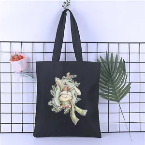 Detail view of black canvas tote bag with cute cartoon rabbit print casual shoulder bag