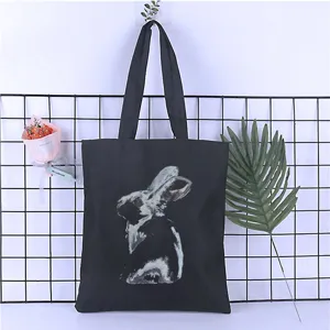 Detailed view of the black canvas tote bag featuring a unique artistic rabbit print design.