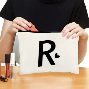 Canvas zipper cosmetic bag detail showing custom letter R print and durable metal closure.