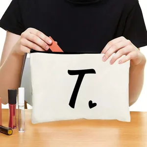 Detail view of canvas zipper cosmetic pouch showing custom letter print and practical storage.