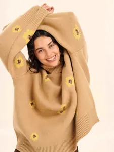 Chic camel turtleneck sweater featuring playful yellow floral intarsia knit pattern for women.