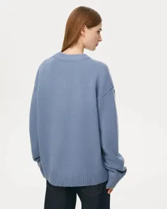 Detailed view of women's cozy blue knit sweater featuring classic crewneck and long sleeves.