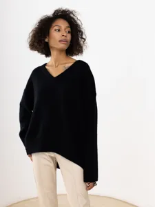 Close-up detail of casual black V-neck long sleeve sweater worn by model in studio.