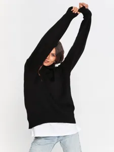 Detailed view of the black oversized turtleneck sweater, soft knit texture and cozy fit.