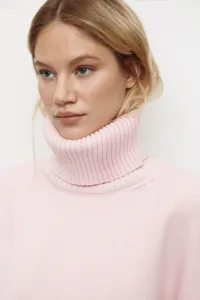 Detail de pull a col roule rose, tricot doux et coupe ample confortable pour la saison.