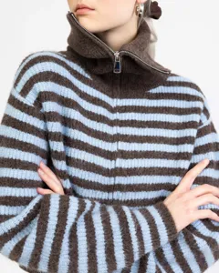 Brown and blue striped half-zip knit sweater detail showing high collar and warm texture.